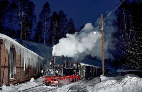 In den Morgenstunden des 15. Januars 2017 startete eine privat organisierte Fotoveranstaltung – im Blitzlicht fährt die IV K 99 1542-2 am winterlichen Jöhstädter Lokschuppen vorbei.