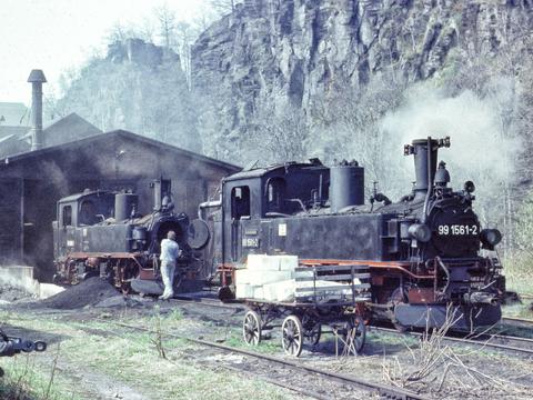 Am 21. April 1985 oblagen die Zugleistungen auf dem verbliebenen Reststück der alten Preßnitztalbahn nach Niederschmiedeberg den Dampflokomotiven 99 1561-2 und 99 1585-1, hier gemeinsam vor dem Heizhaus in Wolkenstein.