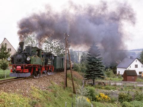 Als diese Strecke von Cranzahl zum Kurort Oberwiesenthal im Juli 1997 ihr 100-jähriges Bestehen feierte, war dieser mit den sächsischen IV K 99 1539-8 aus Radebeul und 99 1590-1 aus Jöhstadt bespannte Zug in der Ortslage Hammerunterwiesenthal unterwegs.