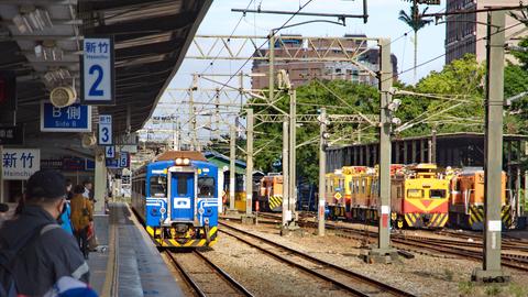 Ein Triebzug der Reihe EMU 600 und dahinter Gleisbaufahrzeuge von Plasser im Bahnhof Hsinchu an der Western Line.