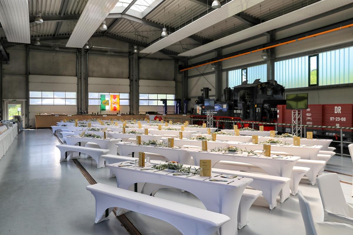Für die Festveranstaltung am 1. Juni mussten Sitzgelegenheiten und Tische für rund 500 Gäste in der Fahrzeughalle aufgebaut werden – am Folgetag sollten hier ab Nachmittag bereits die Modellbahnanlagen aufgebaut werden.