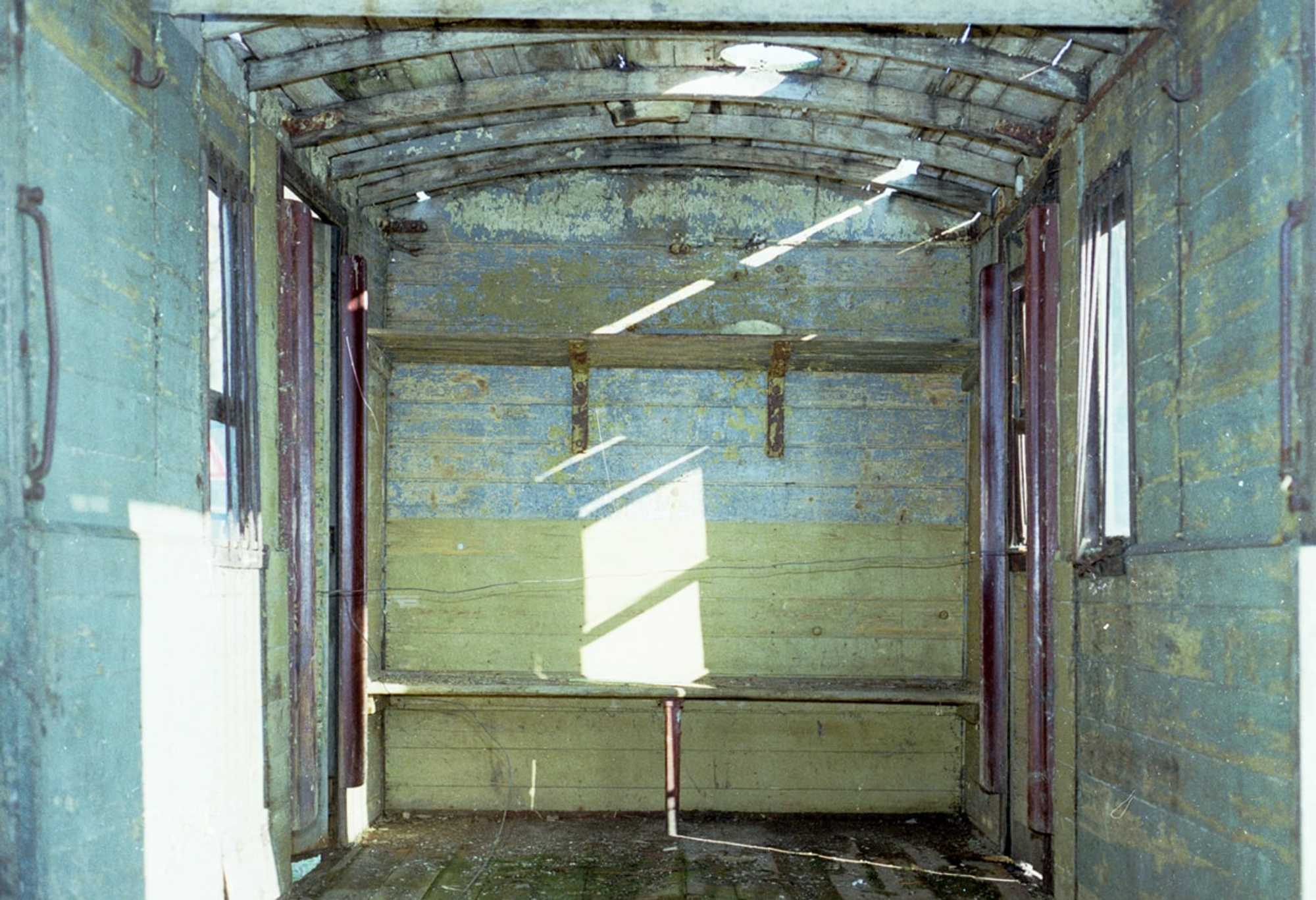 Dieses Bildpärchen zeigt das ehemalige Postabteil des vierachsigen Pollo-Wagens 976-101. Die bei der Bergung des Wagenkastens im Jahr 1994 noch vorhandene originale Sitzbank aus den letzten Einsatzjahrzehnten entstand beim Neubau des Aufbaus ebenfalls neu.