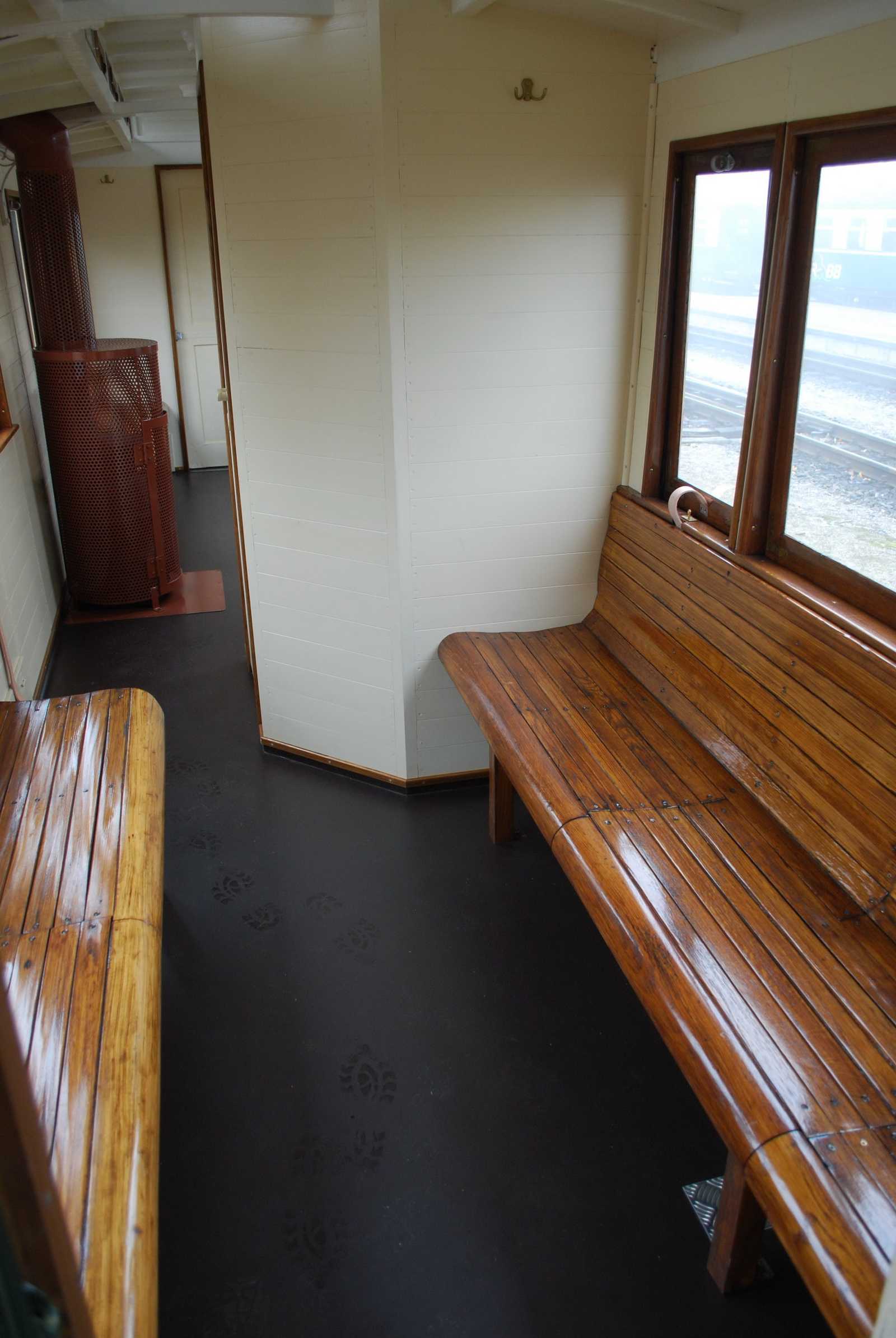 Im Inneren von 970-812 sind die Sitzbänke 3. Klasse längs angeordnet. Hinter dem Abortraum in Wagenmitte ist links der Kohleofen sichtbar.