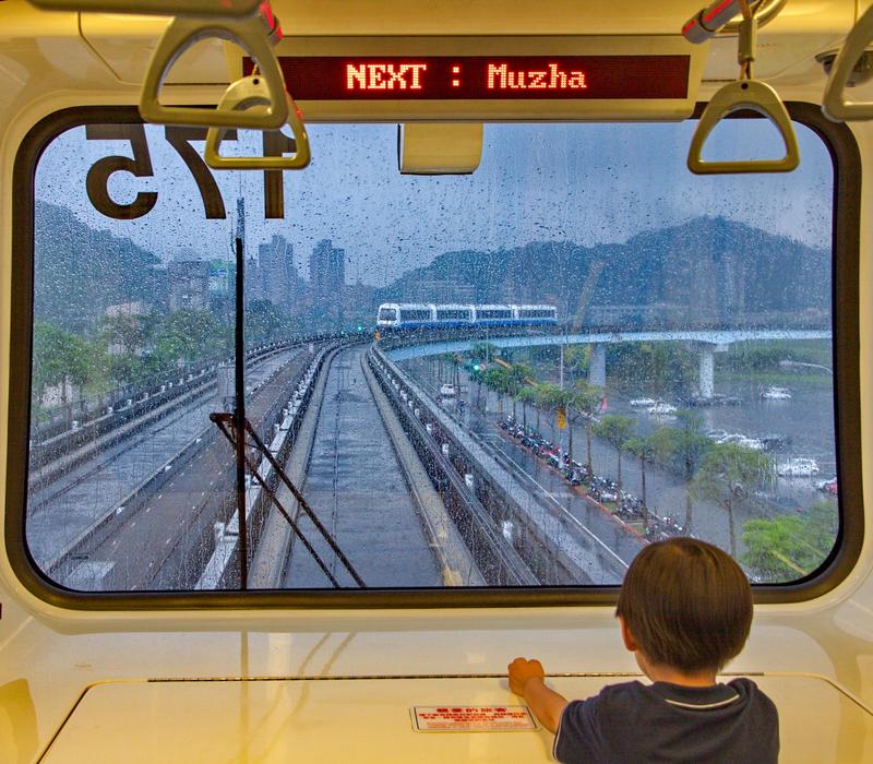 Fahrerlos gibt es schon, auch wenn der kleine Junge im Bild die Position in der Front des Metro-Zuges der gummibereiften „Braunen-Linie“ in Taipei (Taiwan) auf rund 30 km Länge eingenommen hat.