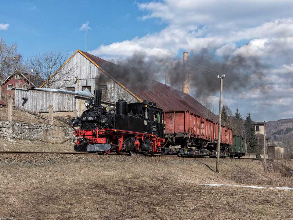 Vom 22. bis 24. März verkehrte die 99 1608-1 auf der Fichtelbergbahn mit Sonderzügen. Am zweiten Tag war sie mit einem Güterzug unterwegs, den Kay Baldauf hinter Hammerunterwiesenthal fotografierte.
