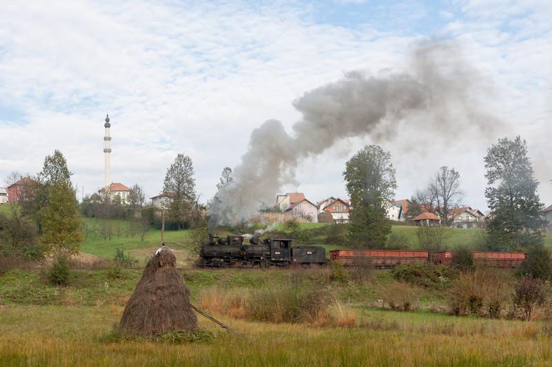 Gleich hinter dem Ort Banovići in Bosnien-Herzegowina fährt am 28. Oktober 2014 83-158 mit ihrem Leer-wagenzug auf der hier zweigleisigen schmalspurigen Kohlenbahn an einer Moschee vorbei.