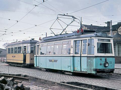 Oft bestritten, aber es gab ihn: den Einsatz gemischtfarbiger Züge. Hier steht der Tw 33 mit einem Waldbahnbeiwagen im November 1964 abfahrtbereit in einer Baustelle am Bahnhof Gotha. Die Gleisschleife befand sich damals im Bau.