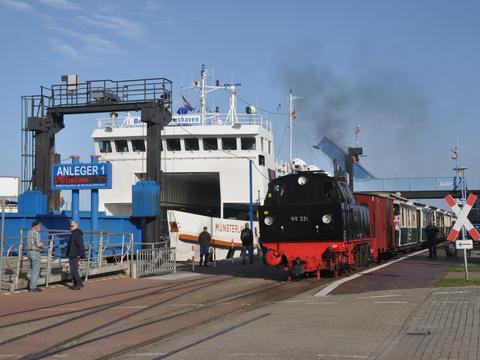 Direkt neben dem Anleger 1 für die Schiffe aus Emden in Niedersachsen und Eemshaven in den Niederlanden können die Reisenden in die Borkumer Kleinbahn umsteigen. Der Anblick der scharz/rot lackierten Dampflok 99 331 war im September eine Attraktion auf der Insel.