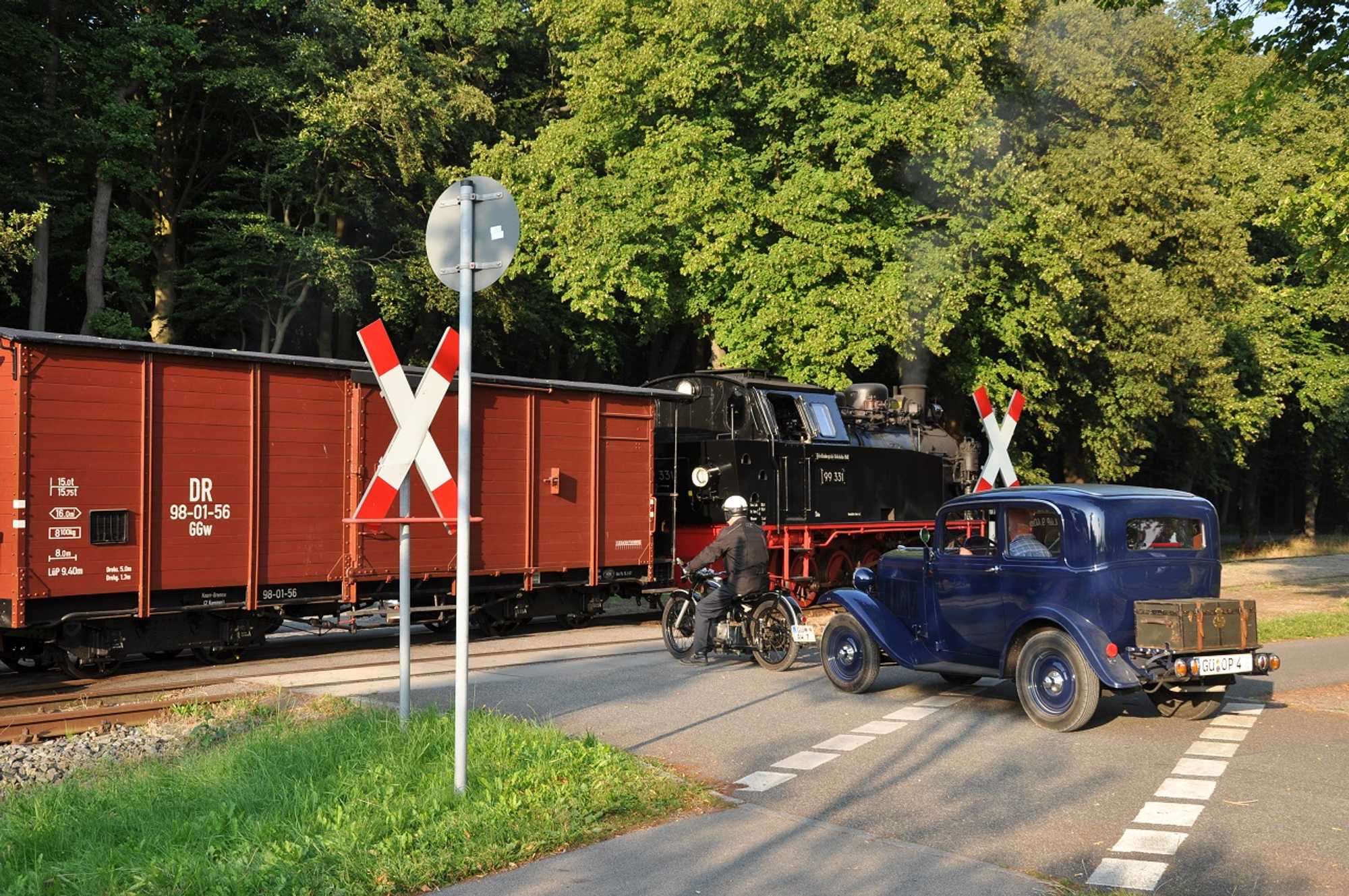 99 331 begegnete im Rahmen der Fotoveranstaltung „Frachtverkehr auf dem Lande“ mit ihrem Gmp-Sonderzug am 26. Juli am Bahnhof Rennbahn diesen zwei- und vierrädrigen Straßenoldtimern.