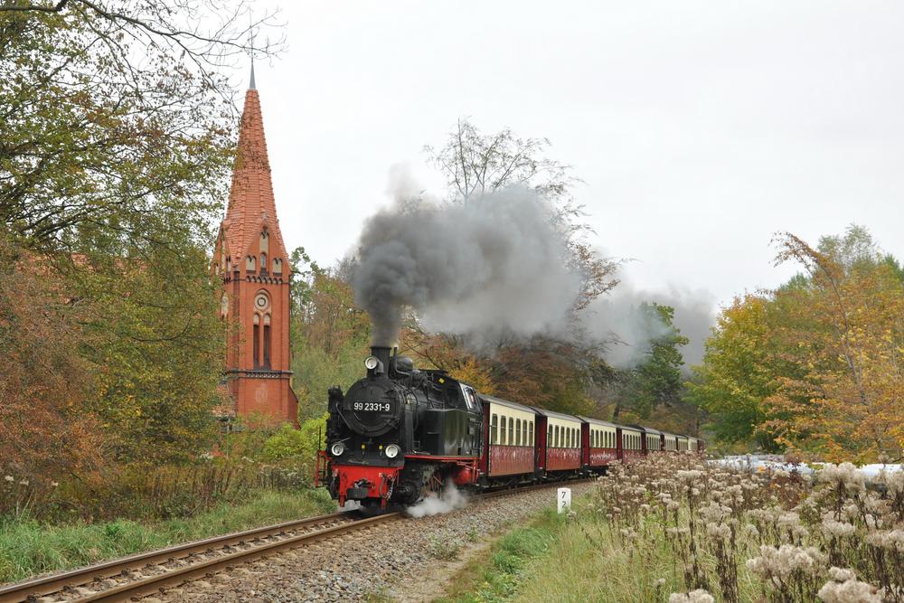 Mit Schornstein voran zog am 20. Oktober 2019 die Lok 99 2331-9 diesen Reisezug nach Kühlungsborn, dadurch konnte am bekannten Kirchenmotiv in Heiligendamm eine Dampflok einmal vorwärts fahrend fotografiert werden.