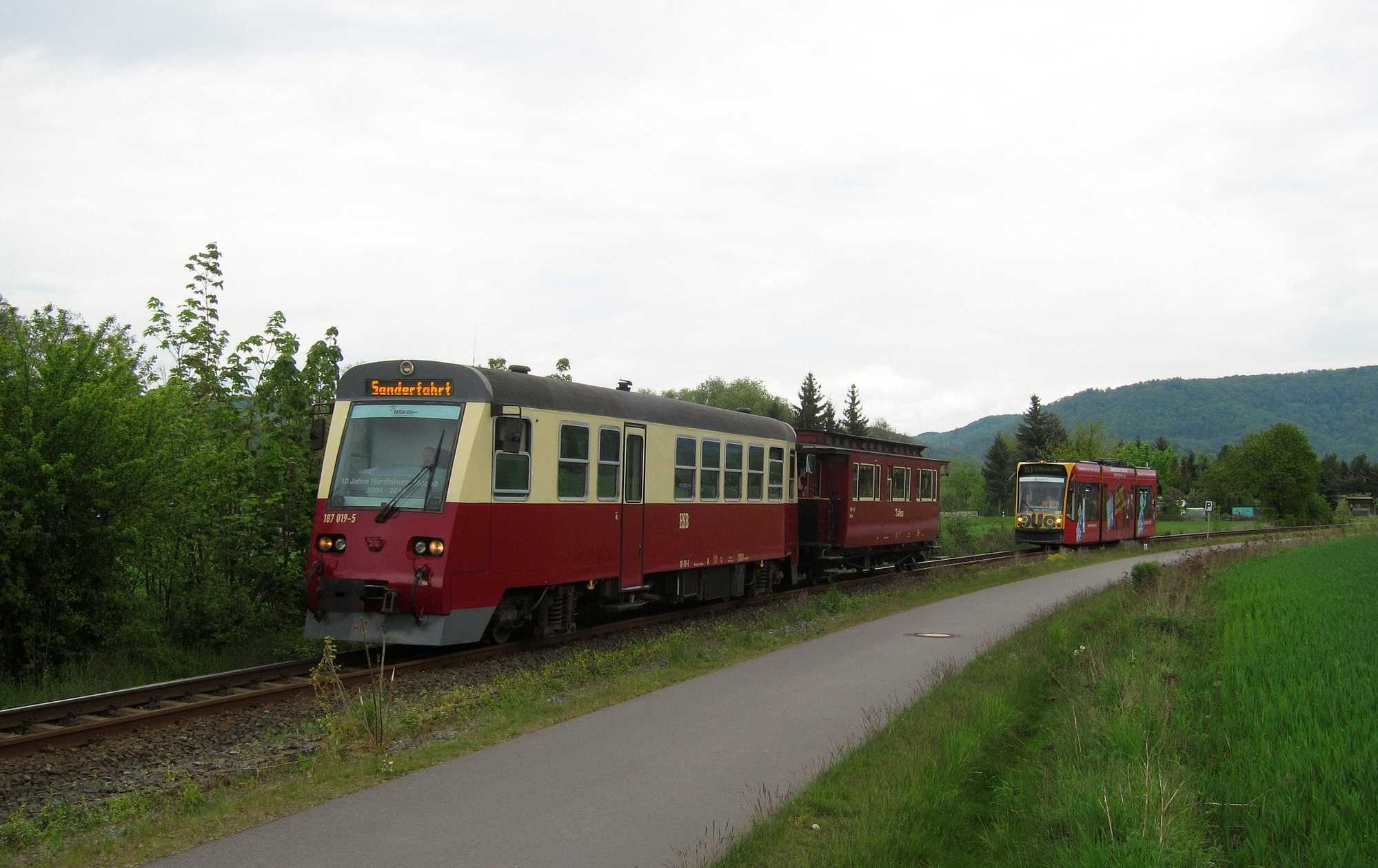Triebwagen 187 019-5 mit Salonwagen sowie im Sichtabstand ein Combino Duo auf dem Weg zur Veranstaltung im Bahnhof Ilfeld.