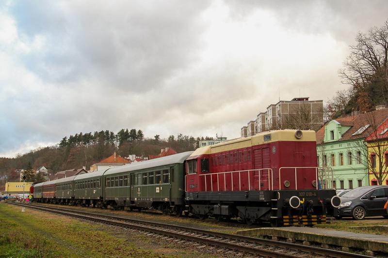 Der VSE-Museumszug wartet am 7. Dezember 2019 mit der nun vorn hängenden Diesel­lok 107 018-4 im Bahn­hof Loket (Elbogen) auf die Rückkehr der Fahrgäste. Ganz hinten steht die V100 der PRESS.