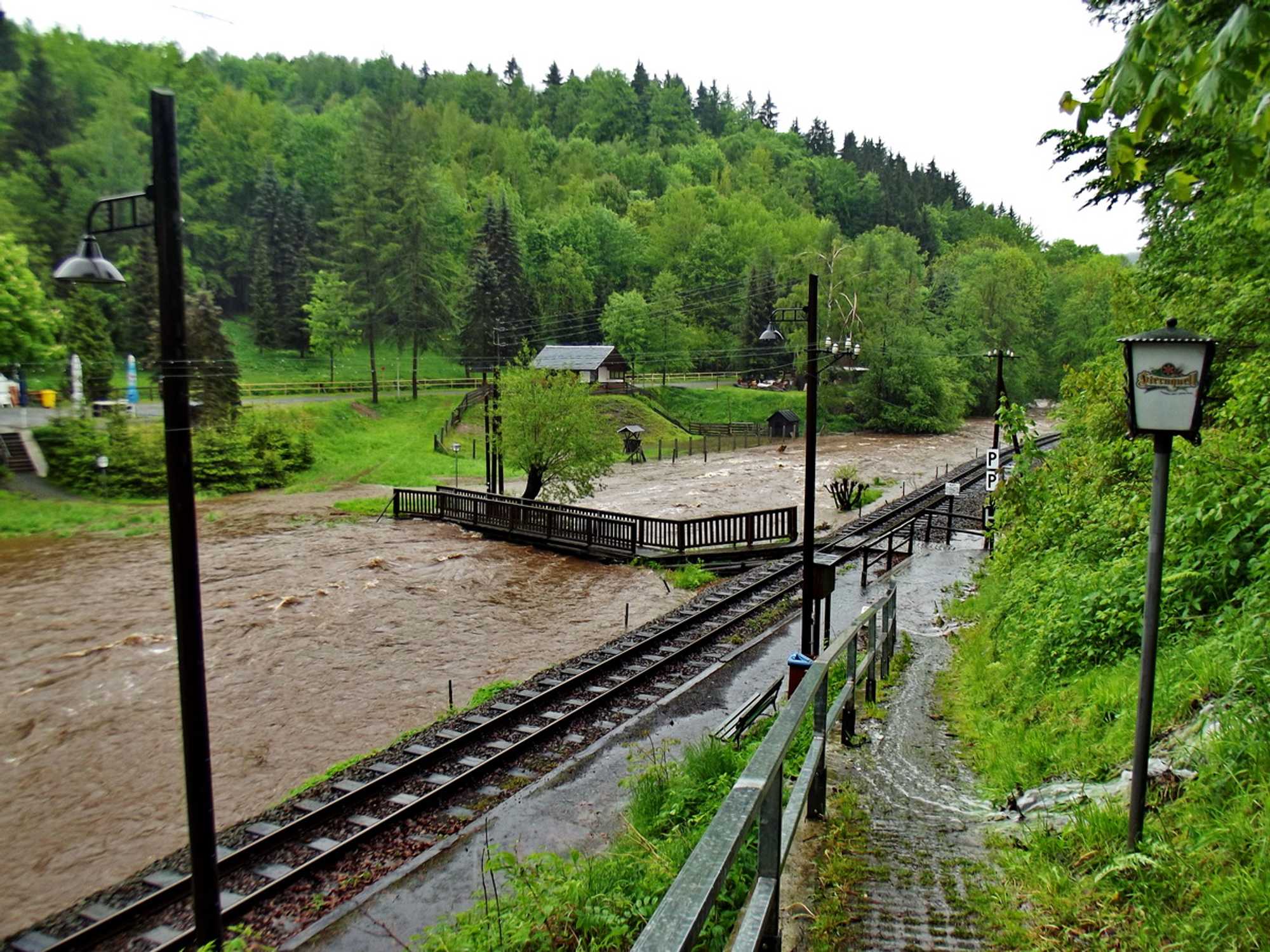 Die Fußgängerbrücke über die Preßnitz steht unter Hochdruck des Wassers, der Weg zur Gaststätte ist bereits überflutet und die Wassermassen von der Straße machen auch den Weg zum Bahnsteig unpassierbar. 2. Juni, 13 Uhr.