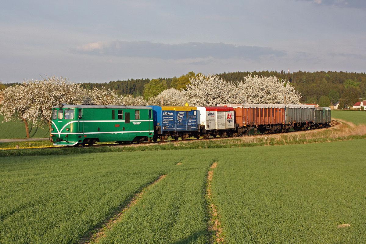Ein Güterzug der JHMD mit zwei auf Rollböcken aufgeladenen Eaos-Regelspurwagen, davor und dahinter jeweils zwei schmalspurige Güterwagen am 4. Mai 2012 mit T47.005 bei Blazejov.