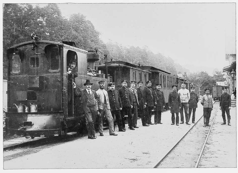 Eventuell im April 1906 entstand in Ortmannsdorf diese Gruppenaufnahme vor einem von der I K Nr. 39 geführten Zug nach Mosel.