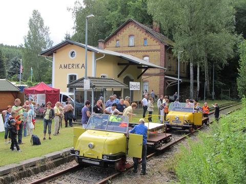 Auf der Muldentalbahn vor dem Festgelände sind die Schienentrabis eingetroffen. Anziehungspunkt und Blickfang ist der restaurierte Güterschuppen des ehemaligen Bahnhofs Amerika. Am 15. Juli 2012 hielt Thomas Wiegandt diese Szene im Bild fest.