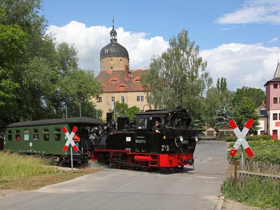 99 4511-4 erstmalig zu Gast auf der Döllnitzbahn, hier mit einem Zug in der Nähe des Mügelner Schlosses.
