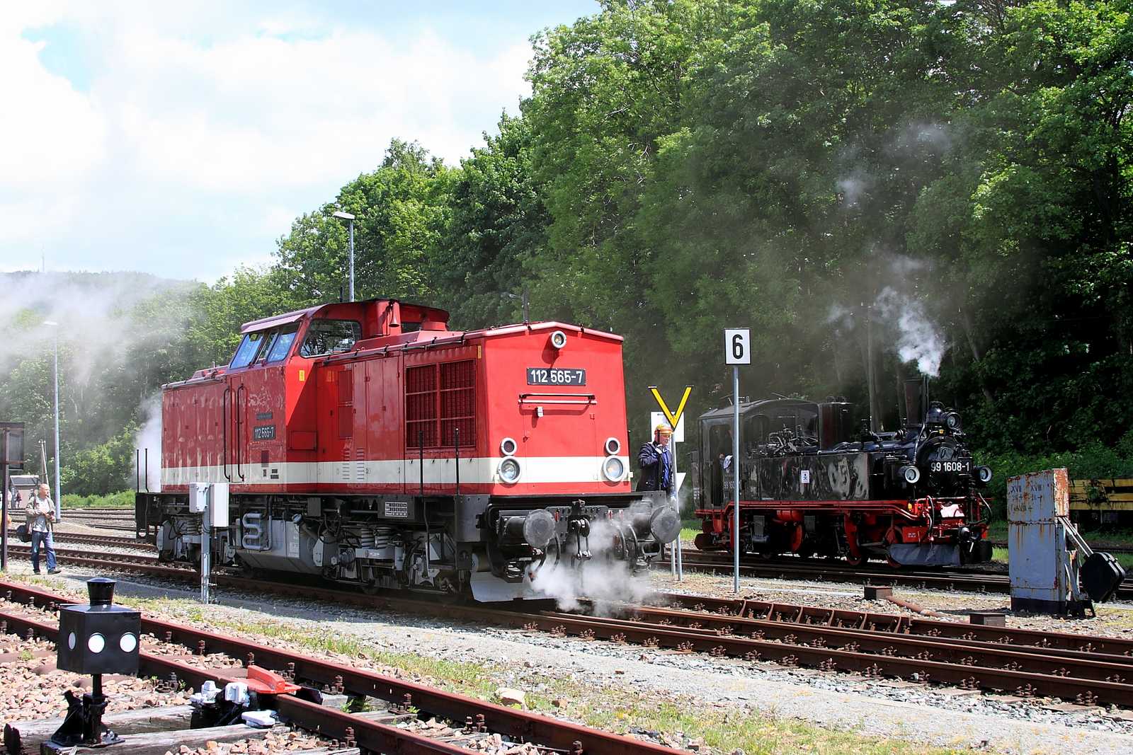112 565-7 der PRESS rangiert beim Bahnhofsfest in Cranzahl, während 99 1608-1 der SDG Fichtelbergbahn auf dem Schmalspurgleis bereitgestellt wird.