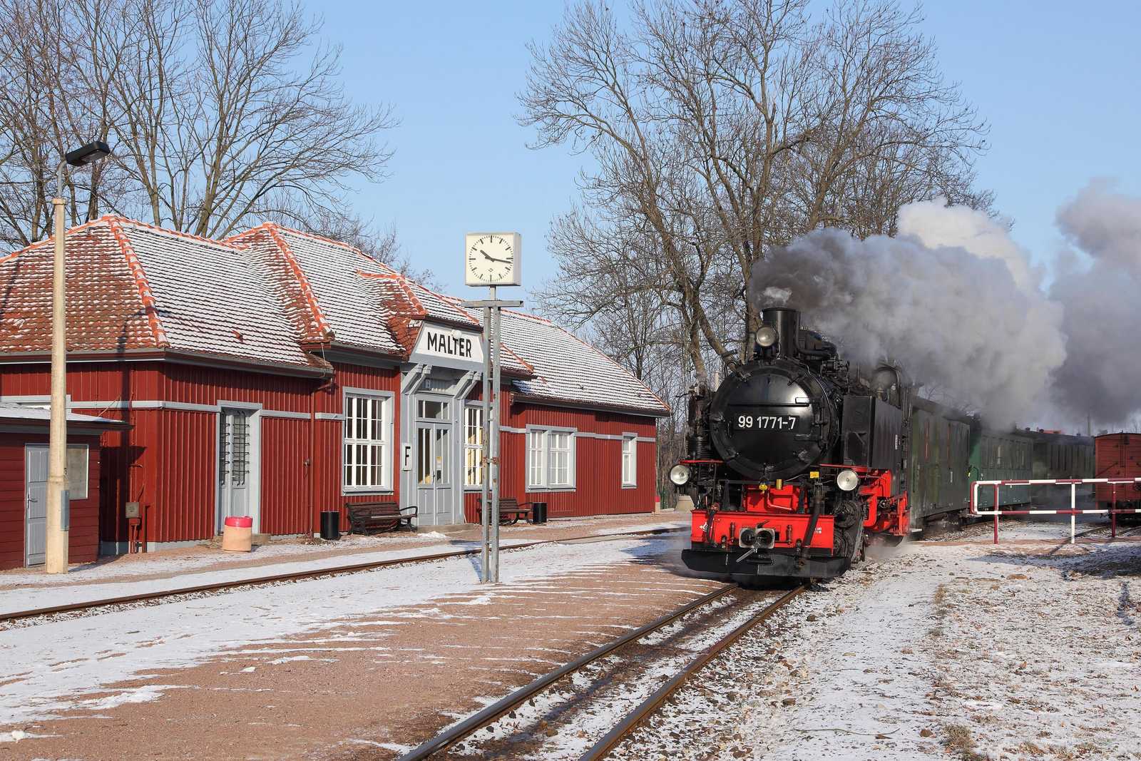 Ein Zug mit 99 1771-7 vor dem vorbildlich erhaltenen Bahnhofsgebäude von Malter.