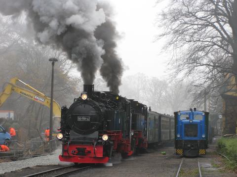 Am 24. November absolvierte 99 1781-6 vor 99 1784-0 als Zuglok ihre Lastprobefahrt zwischen Göhren und Putbus. Hier startet der Zug gerade an der Baustelle des Bahnhofs Göhren. V10C 199 008-4 der Preßnitztalbahn steht für Arbeitszugtzwecke in Göhren bereit.