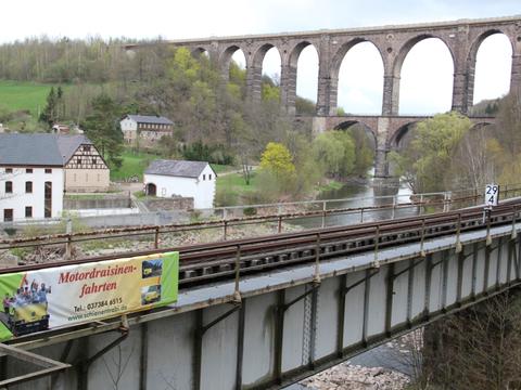 An der Brücke über den Cossener Bach wirbt nun ein Werbeplakat für die Schienentrabifahrten im Muldental.
