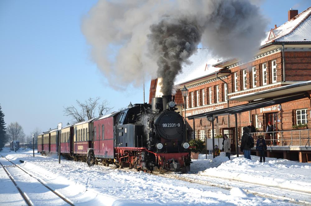 Im Sonnenschein wartet 99 2331-9 mit ihrem Zug am 28. Dezember 2010 auf das Abfahrtssignal aus dem Bahnhof Ostseebad Kühlungsborn-West.
