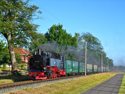Die Lok 99 783 war am 4. Juli 2021 mit einer für die RüBB typischen Sommergarnitur unterwegs, hier zwischen Baabe und Sellin fotografiert.