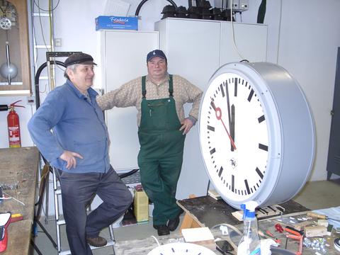 Wolfgang Friedel und Peter Wolf mit der Hallenuhr vor ihrer Montage.