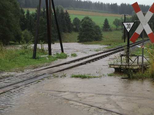 Ein einprägsames Bild vom Hochwasser im August 2002 ist das über die Ufer getretene Schwarzwasser, das auf Höhe der künftigen Fahrzeughalle die Gleise der Preßnitztalbahn quert.