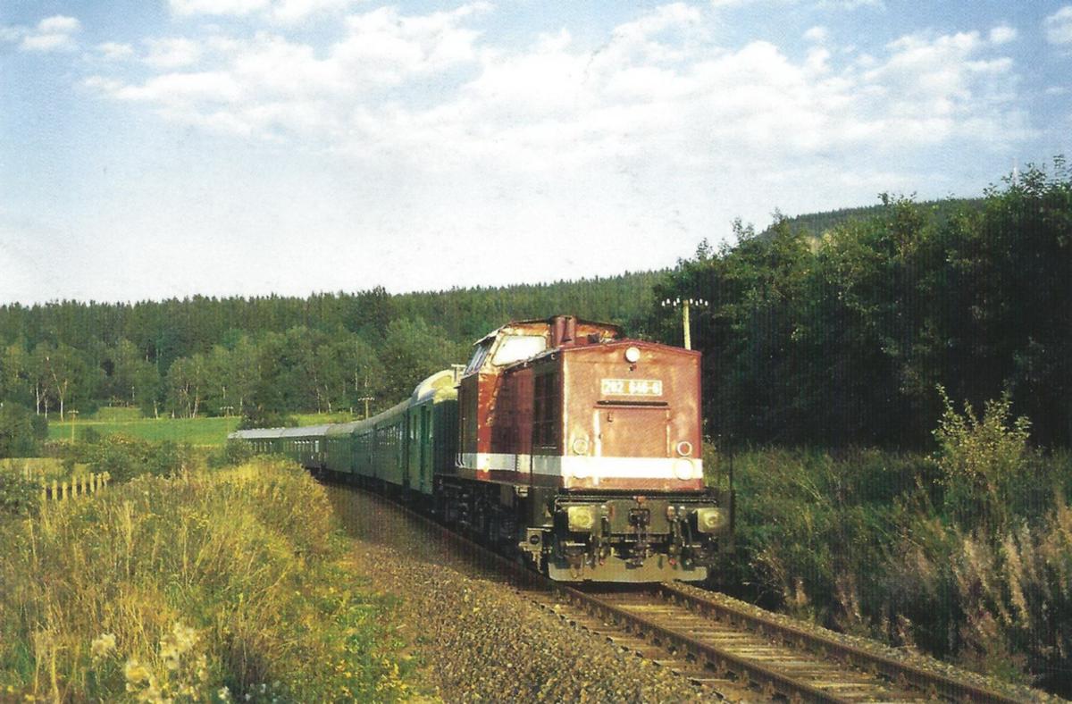 Im glänzenden Abendlich fährt die Lok 202 646 der DB-Erzgebirgsbahn am 4. September vor der Kulisse des Bärensteins anläßlich des diesjährigen Böhmisch-Sächsischen Eisenbahnfestivals mit einem Sonderzug zwischen dem ehemaligen Bahnhof Königswalde ob. Bf und Cranzahl.