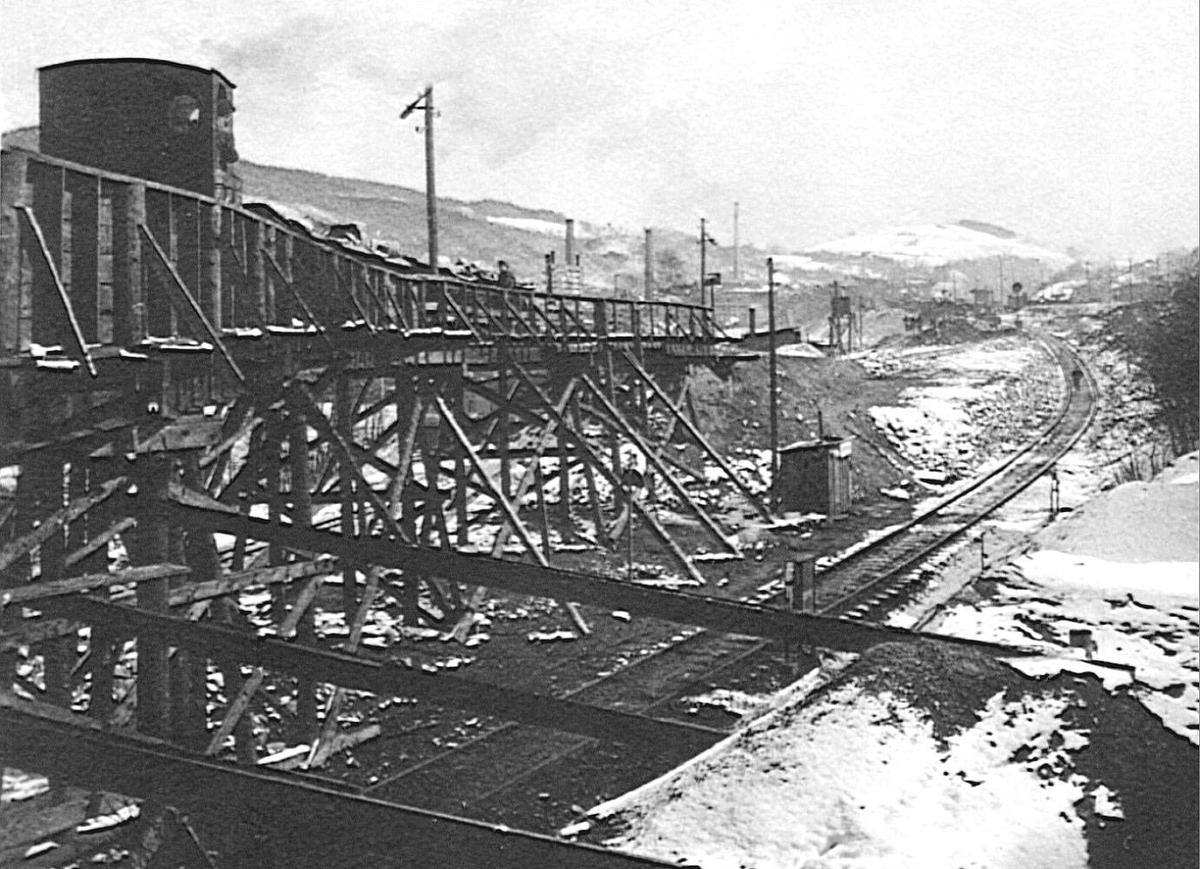 Die Holzbrücke der Feldbahn über die noch eingleisige Strecke zur Geländeanschüttung unterhalb des Bahnbetriebswerkes.