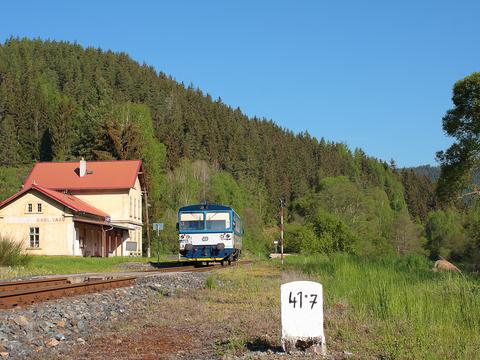 Ganz im Westen der Tschechischen Republik gibt es vom 1. Mai bis zum 31. August 2022 an den Wochenenden im Tepltal südlich von Karlsbad einen Umlauf mit einem Triebwagen der Reihe 810. Dieser verlässt 8.05 Uhr Karlovy Vary dolní nádraží (Karlsbad unt Bf) und fährt bis Krásný Jez (Schönwehr). Von dort pendelt er viermal ins sechs Kilometer entfernte Horní Slavkov-Kounice (Leßnitz). Dann fährt er 18.04 Uhr zurück nach Karlovy Vary (Ankunft 18.48 Uhr). Das Foto von Dominik Dietrich zeigt den Triebwagen 810 548 am 15. Mai 2022 im Hp Teplička u Karlových Varů (Töppeles) auf der Fahrt nach Krásný Jez.