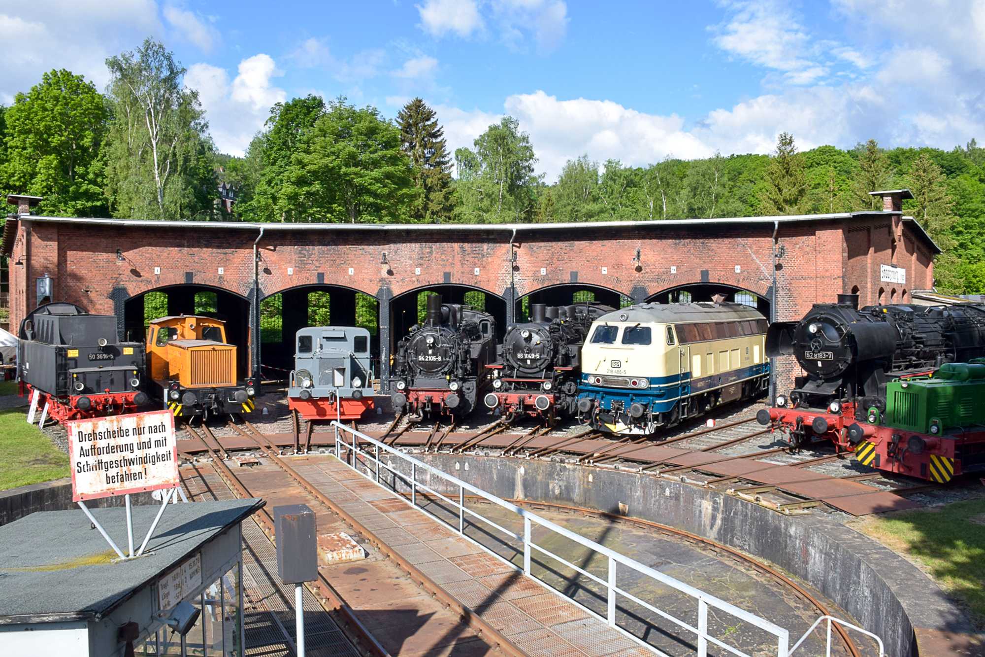 Parade während der Schwarzenberger Eisenbahntage vor dem Lokschuppen des Eisenbahnmuseums: Unter den Fahrzeugen befindet sich auch die Gastlok 218 488-5 und der Tender der Vereins-50er.