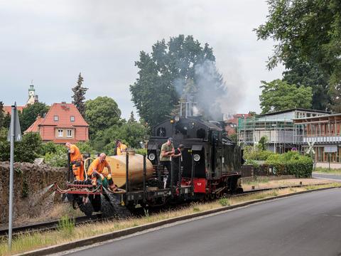 Am 7. Juni 2022 setzte die SDG auf der Lößnitzgrundbahn einen Sprengzug zur Unkrautbekämpfung ein. Dazu kamen die VI K 99 713 und der mit einem Flüssigkeitsbehälter beladene HH 97-25-52 zum Einsatz, hier im Bereich der Pestalozzistraße vor dem Hp Weißes Roß.