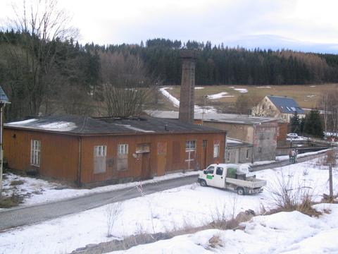 Blick auf Lagerschuppen, Heizhaus mit Schornstein und Kohlelager