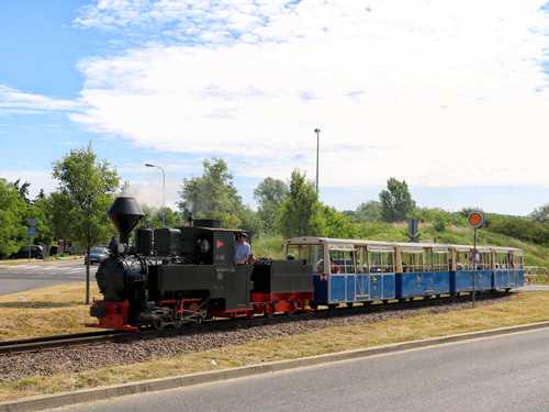 Mit diesen blauen Wagen ein ungewohnter Anblick: Die Dampflok 99 3301 aus Cottbus zu Gast bei der Parkeisenbahn Maltanka in Posen – hier am 18. Juni 2022 im Bereich der Therme.