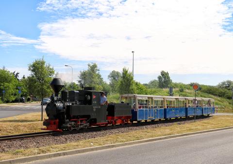 Mit diesen blauen Wagen ein ungewohnter Anblick: Die Dampflok 99 3301 aus Cottbus zu Gast bei der Parkeisenbahn Maltanka in Posen – hier am 18. Juni 2022 im Bereich der Therme.