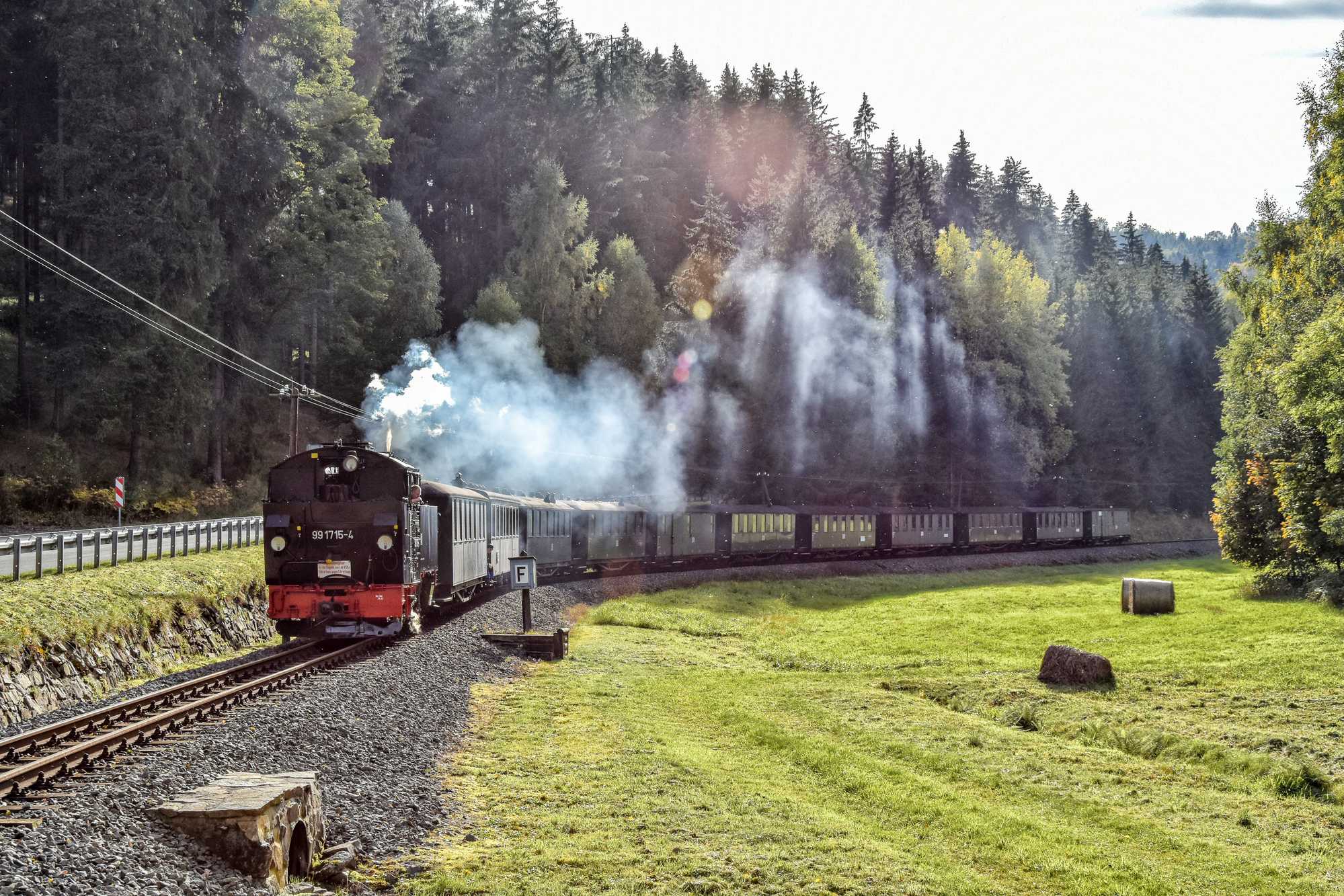 Die Lastprobefahrt der VI K 99 1715-4 fand am 5. Oktober 2022 mit elf Reisezugwagen statt. Thomas Poth traf den langen Zug talwärts fahrend kurz vor dem Bahnübergang des Abzweigs nach Grumbach – die 1927 gebaute Lokomotive beförderte die Wagen aber auch mühelos nach Jöhstadt zurück.
