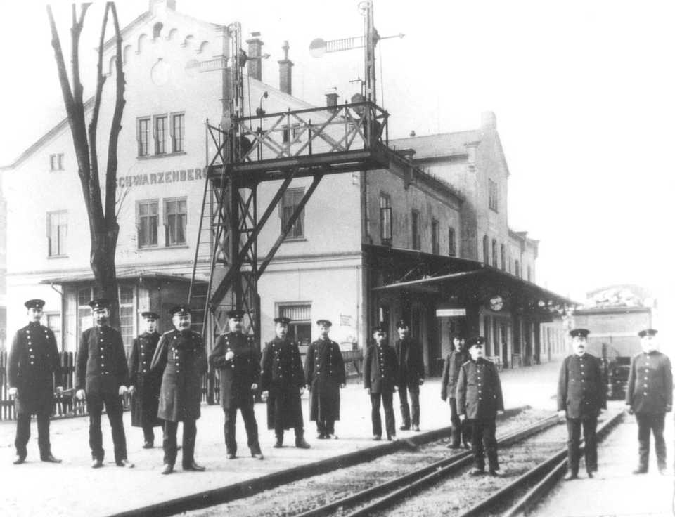 Um 1912 stellen sich die Eisenbahner des Bahnho­fes Schwarzenberg zum Gruppenbild, am Haus­bahnsteig befindet sich noch eine Signalbrücke.