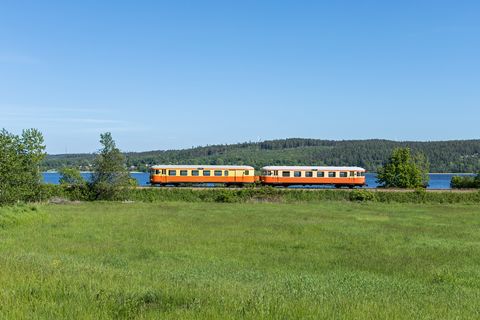 Schwedische Sommeridylle: Mit dem Steuerwagen UBFo3yp 2120 an der Spitze fährt der Schienenbus YBo5p 913 am 5. Juni 2022 entlang des Sees Anten nach Gräfnäs.