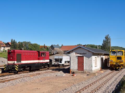 Gleisbau im oberen Abschnitt der Weißeritztalbahn: Am 20. August 2016 wurde der von Diesellok L45H-084 geführte Schotterzug in Obercarsdorf beladen, rechts die Gleisstopf- und Richtmaschine.
