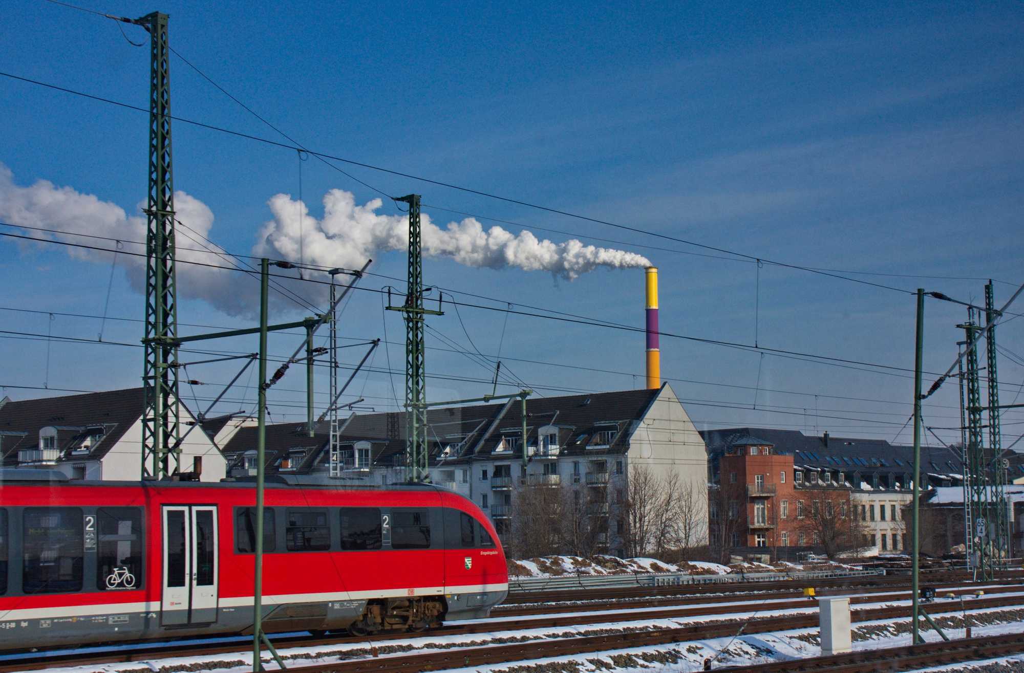 Ein Triebwagen der DB Erzgebirgsbahn in der Ausfahrt aus dem Chemnitzer Hauptbahnhof vor der Kulisse der imposanten Esse des Chemnitzer Heizkraftwerkes. Mit der Umstellung der Strecke Leipzig - Chemnitz auf den Betrieb durch die MRB haben sich auch viele Anschlussbeziehungen in Chemnitz nicht gerade verbessert.